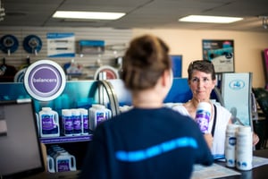 A shop clerk helping a customer while using Evosus Software. 